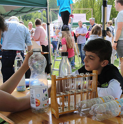 Experiment mit Reagenzgläsern und Wasserflaschen an einem MINT-Stand